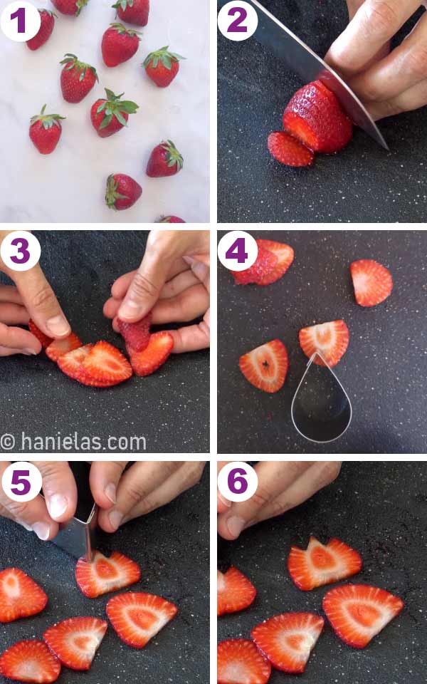 A black cutting board with a sliced strawberry on it.