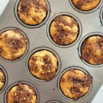 Baked muffins in a dark silver muffin pan.