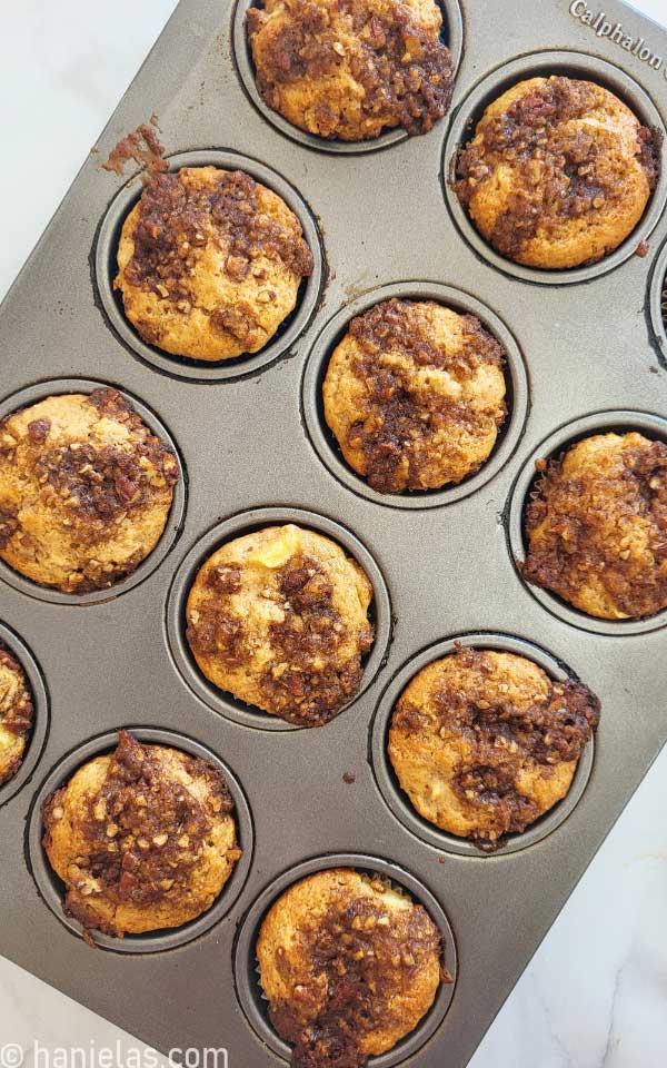 Baked muffins in a dark silver muffin pan.