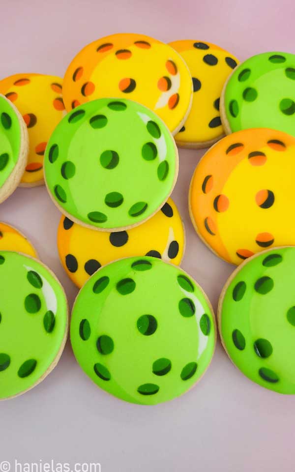 Decorated round cookies that look like pickleball.