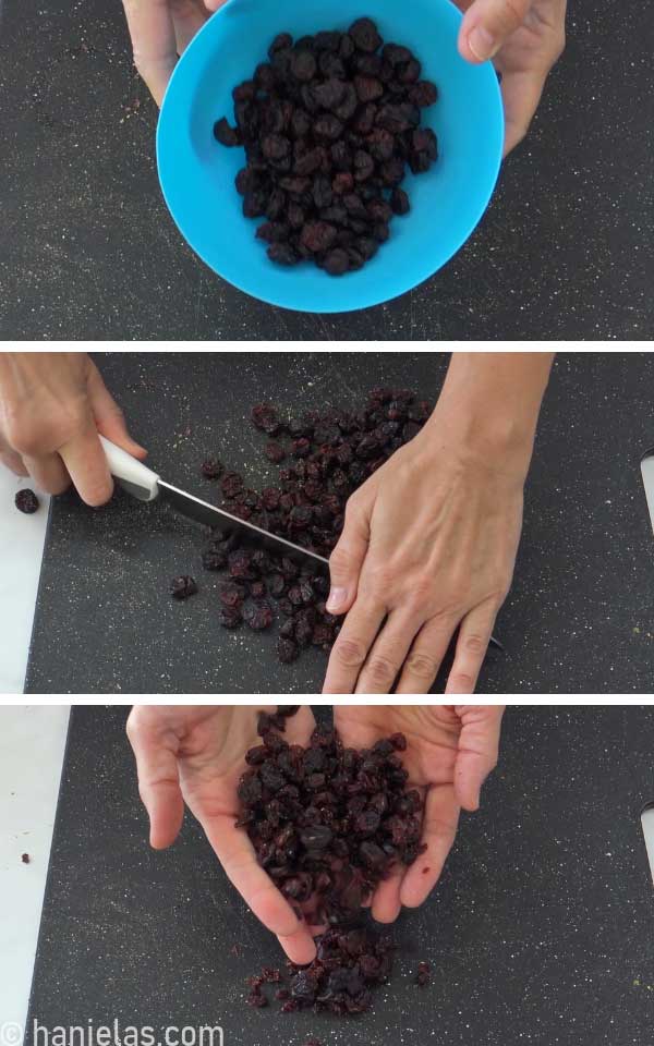 Dried cranberries, cut on a black cutting board.