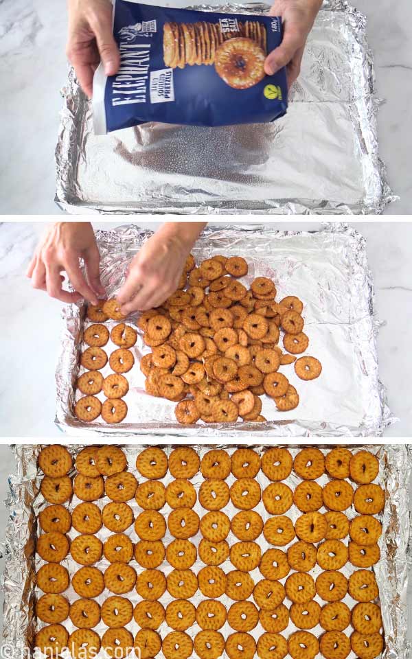 A baking sheet lined with foil, with a layer of pretzel thins.