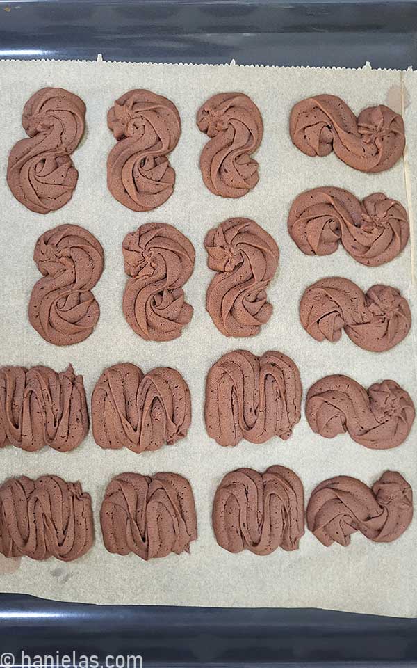 Baked chocolate cookies on a baking sheet lined with parchment.