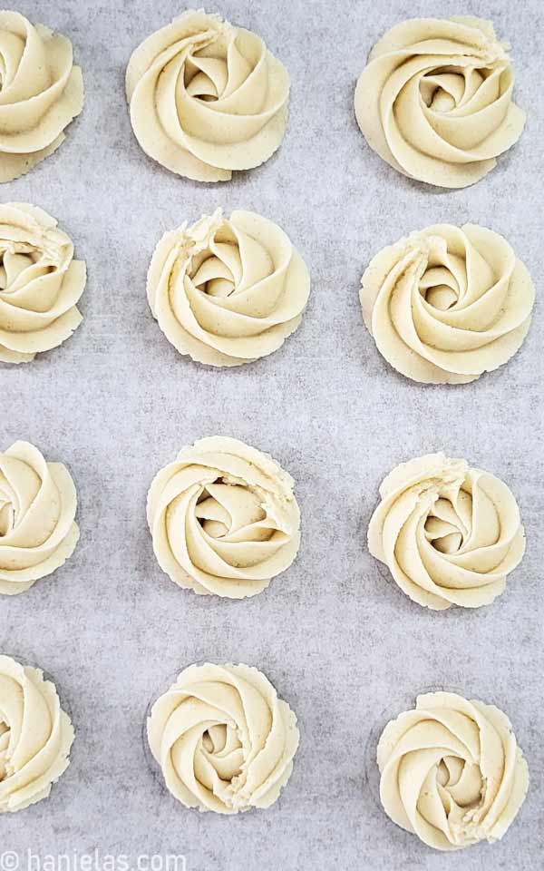 Unbaked swirls of cookie dough on a baking sheet lined with parchment.