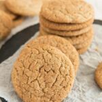 Round flat cookies stacked on a parchment.