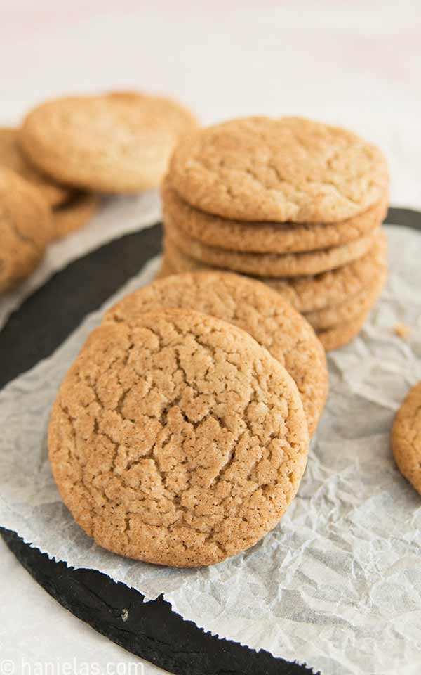 Round flat cookies stacked on a parchment.