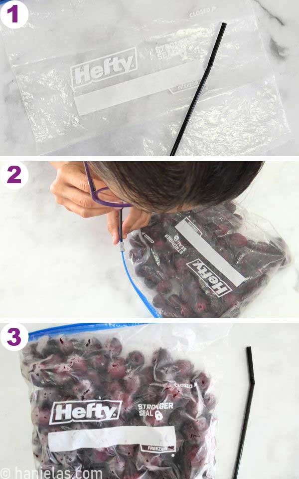 Person removing air from the ziploc bag with frozen cherries.