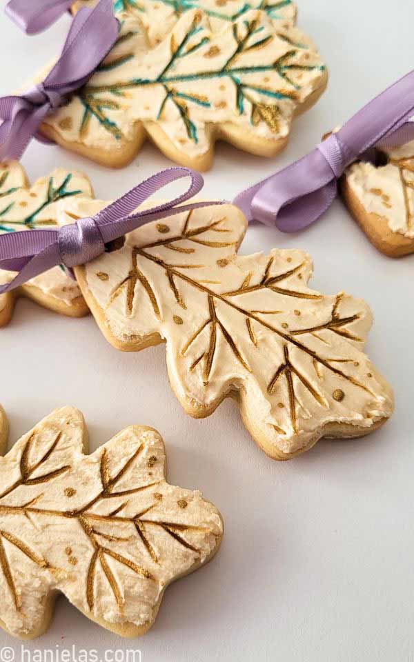 A detail of a cookie decorated with icing and painted with gold luster dust.