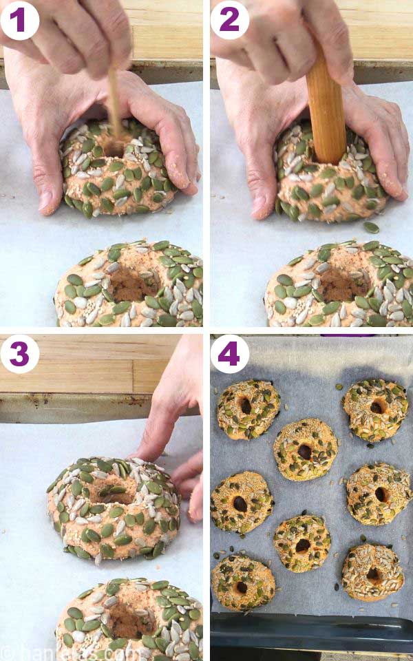 A hand holding a wooden spoon, making a hole in a bagel.