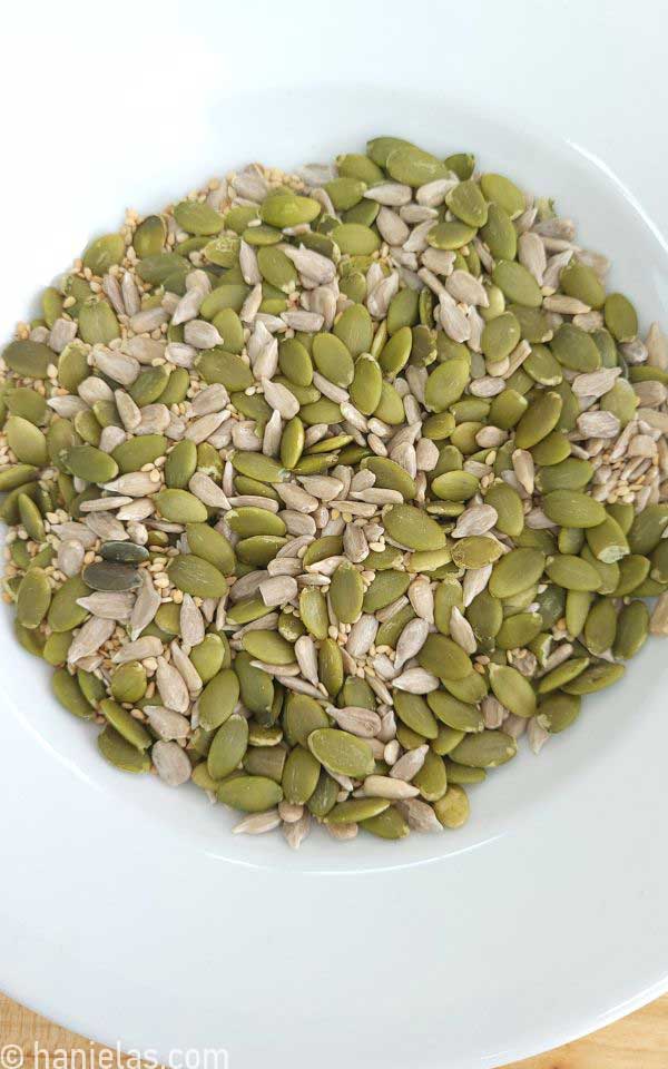 A plate with pumpkin, sunflower and sesame seeds.
