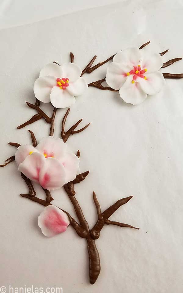 Piped brown tree branch decorated with piped dry white and pink flowers.