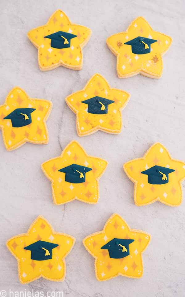 Decorated cookies in a star shape, adorned with a graduation cap transfer.