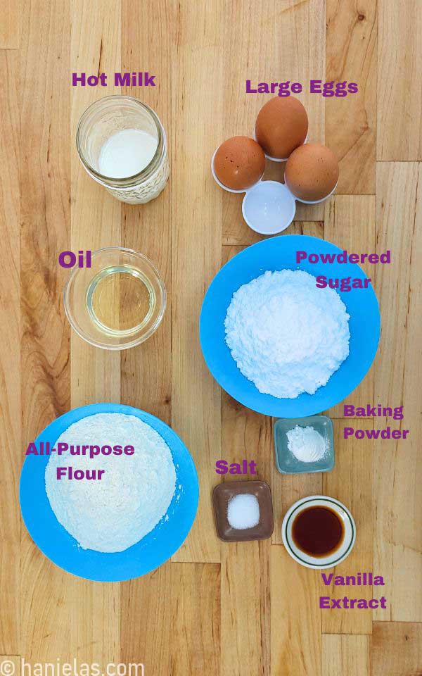 Ingredients for a cake in small bowls on a butcher's block.