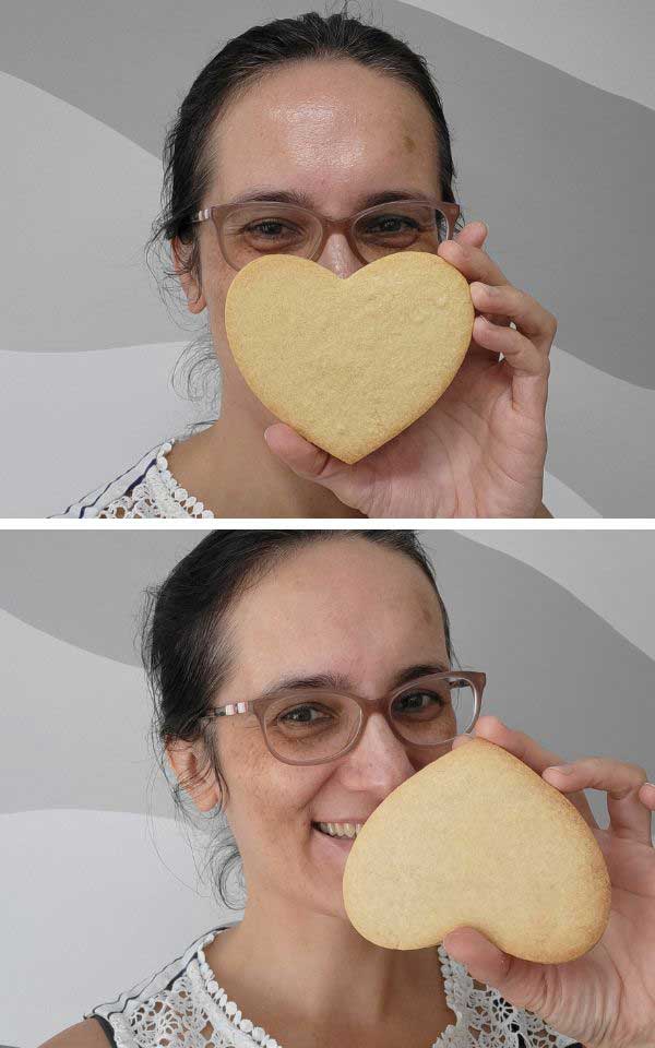 A woman holding a cookie in front of her face.