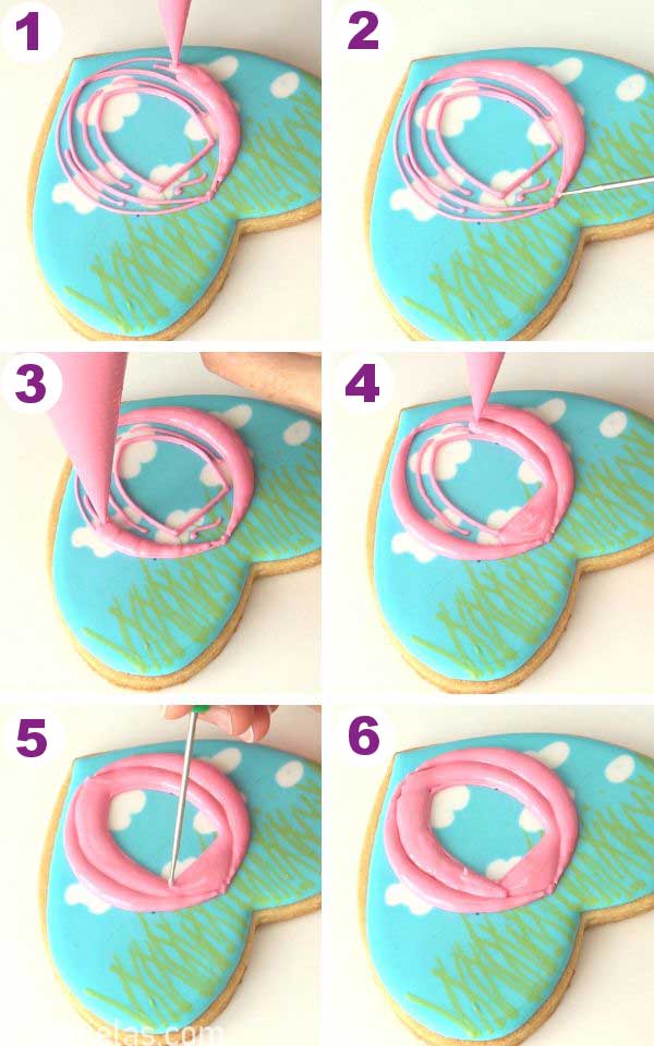 Piping pink icing onto the cookie.