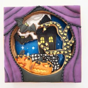 An image of decorated diorama cookie, featuring layers of decorated cookies.