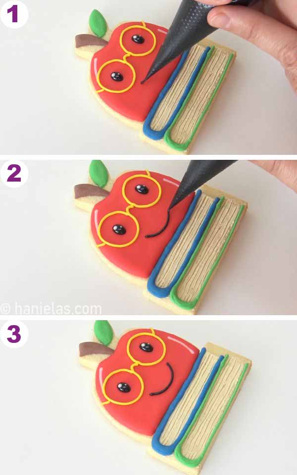 Piping a mouth with black icing onto the cookie.