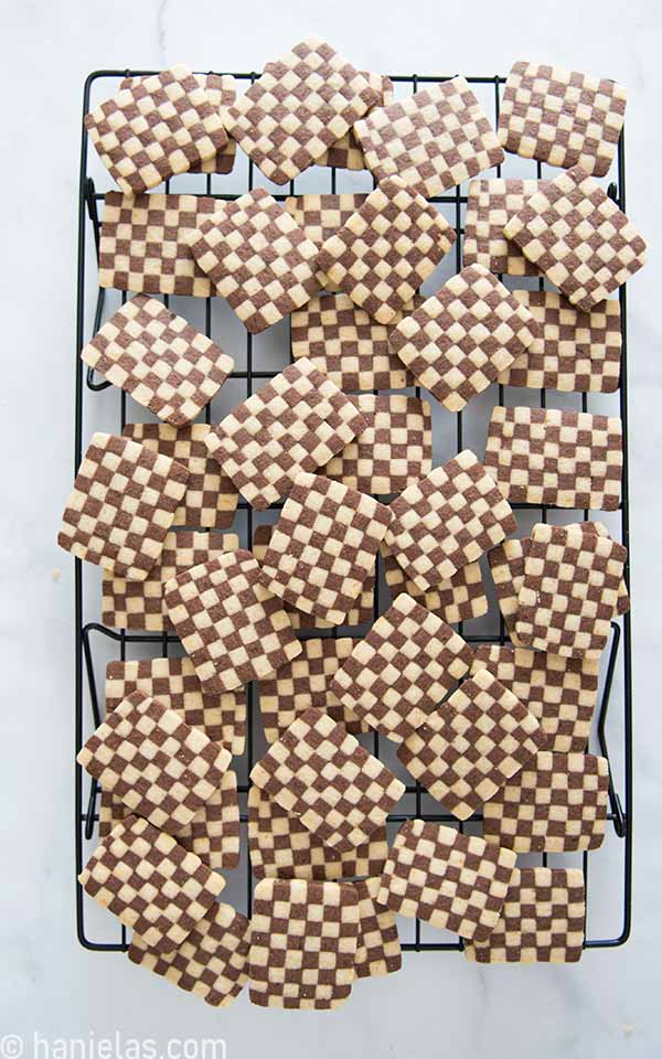 Baked cookies stacked on a cooling rack.