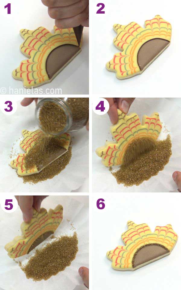 Adding brown sanding sugar on the line of piped royal icing.