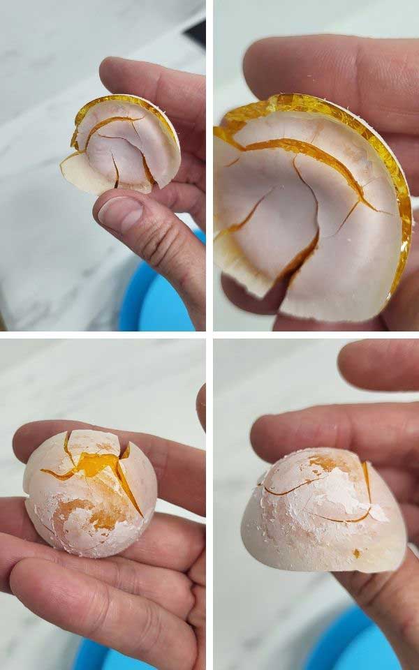 Fingers holding a dried up egg.