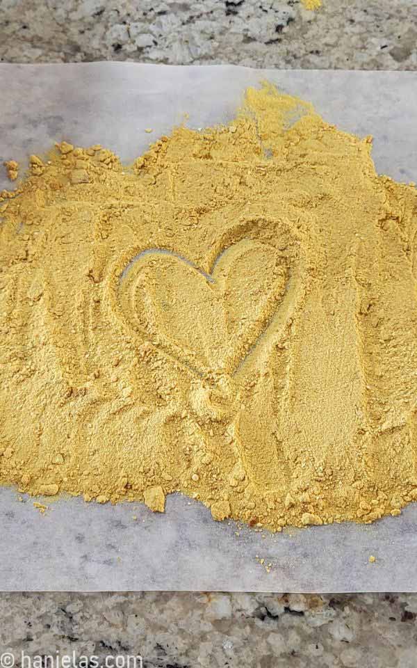 Toasted milk powder spread over a piece of parchment to cool.