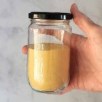 A glass jar with toasted milk powder.